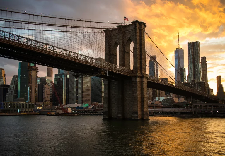 New York City Manhattan downtown skyline and Brooklyn bridge at sunset