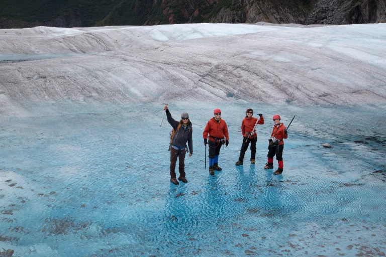 Four people standing on Mendenhall Glacier, Alaska, USA