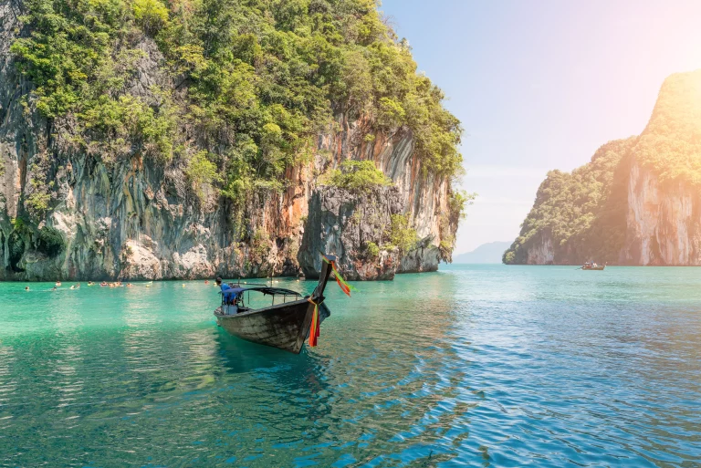 Beautiful landscape of rocks mountain and crystal clear sea with longtail boat at Phuket, Thailand