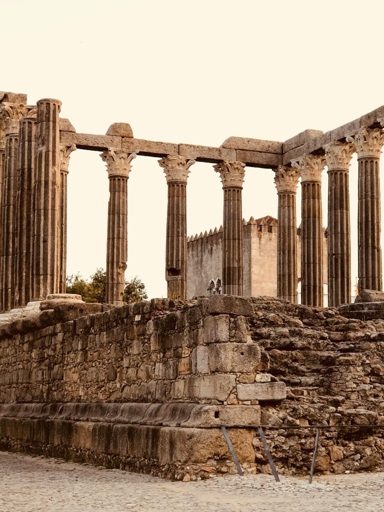 Explore the Évora ancient Roman temple ruins featuring iconic columns and historic architecture in daylight.