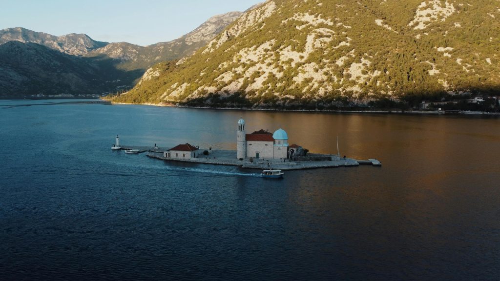 Scenic aerial view of Our Lady of the Rocks island in Perast, Montenegro, surrounded by the stunning bay.